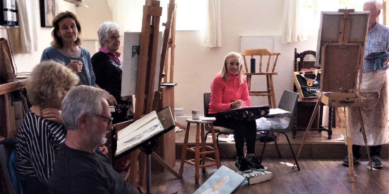 A group of artists in the community centre drawing and painting
